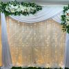 Aluguel de Painel de Cortinas Branco Suporte Duplo Com Cortinário, Led, Folhagens e Flores Brancas Para Decoração de Festas e Eventos. Este painel de cortinas branco