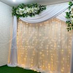 Aluguel de Painel de Cortinas Branco Suporte Duplo Com Cortinário, Led, Folhagens e Flores Brancas Para Decoração de Festas e Eventos. Este painel de cortinas branco